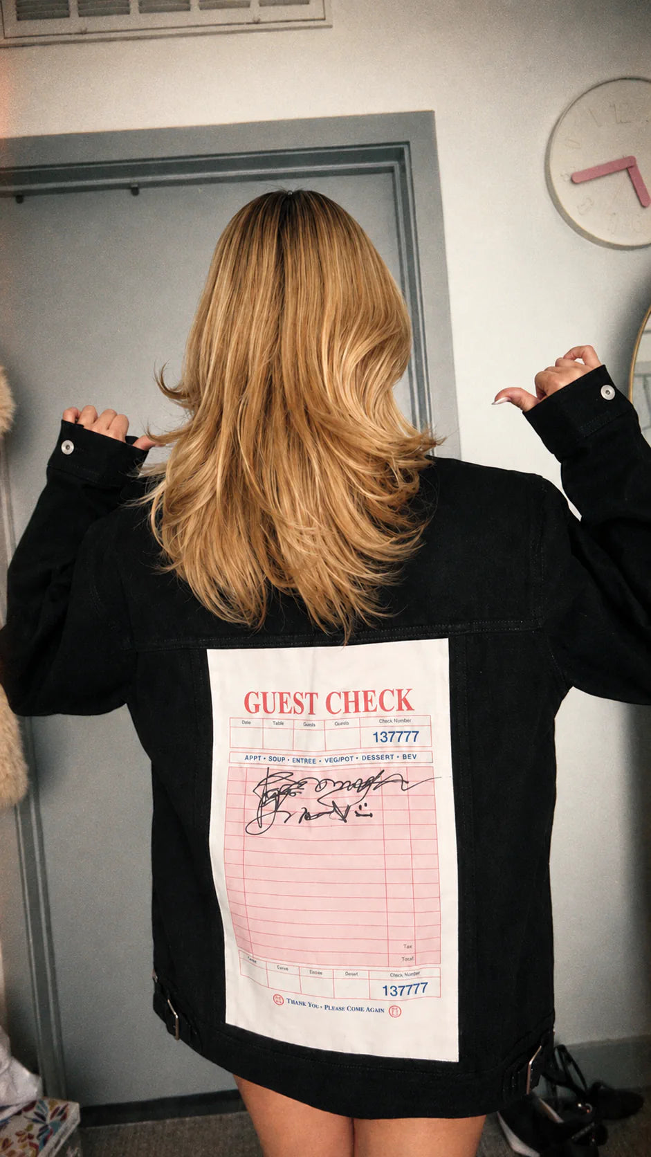 Back of a black jacket with a pink guest-check art panel.