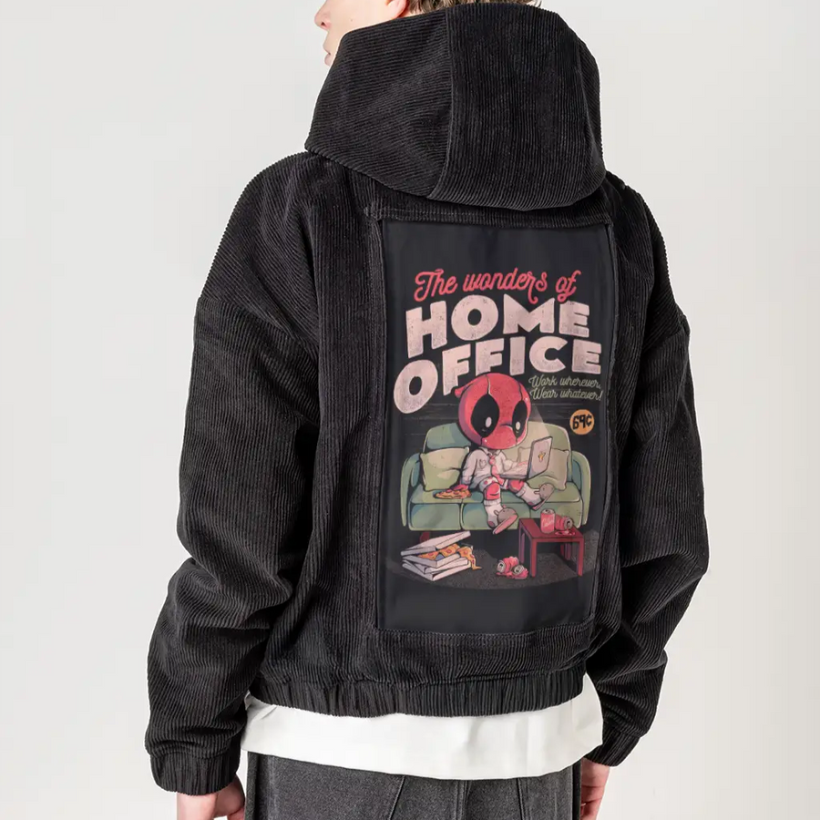 Person wearing a black jacket with a graphic design on the back, standing against a plain background