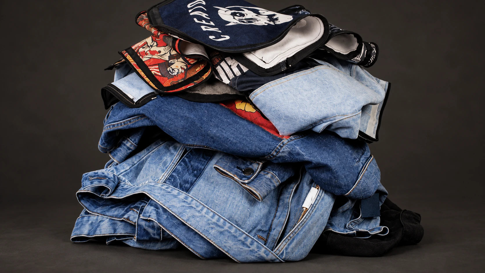 A stack of early SwapWear denim garments and art-panel prototypes.