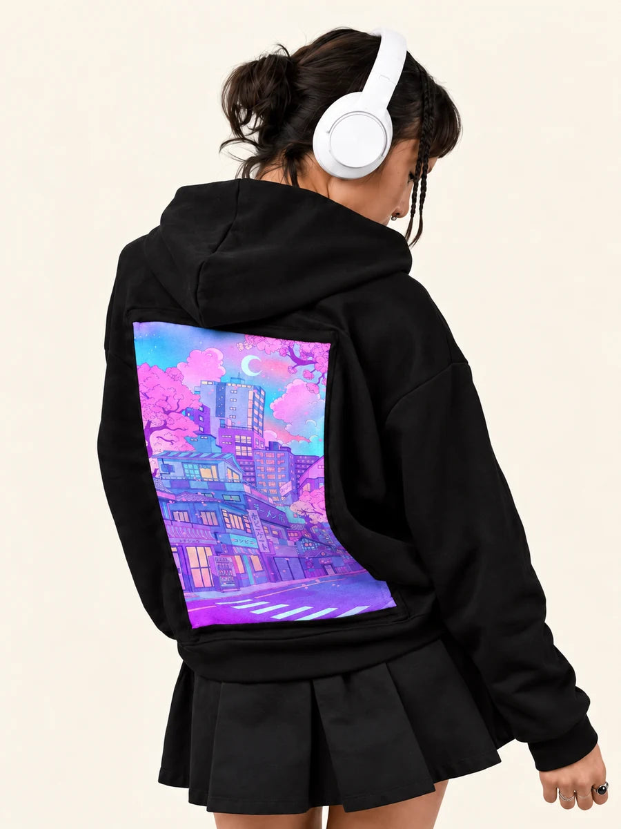 After Hours Hoodie with Blossom City art, worn by a woman in headphones turning to the right.