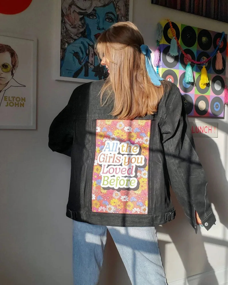 Creator wearing a Raven denim jacket with All The Girls You Loved Before floral art and a blue hair ribbon.